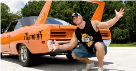 John Cena poses with his flashy orange car.